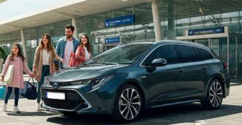 Happy family picking up a black Toyota Corolla Hybrid Touring Sport rental car at Malaga Airport